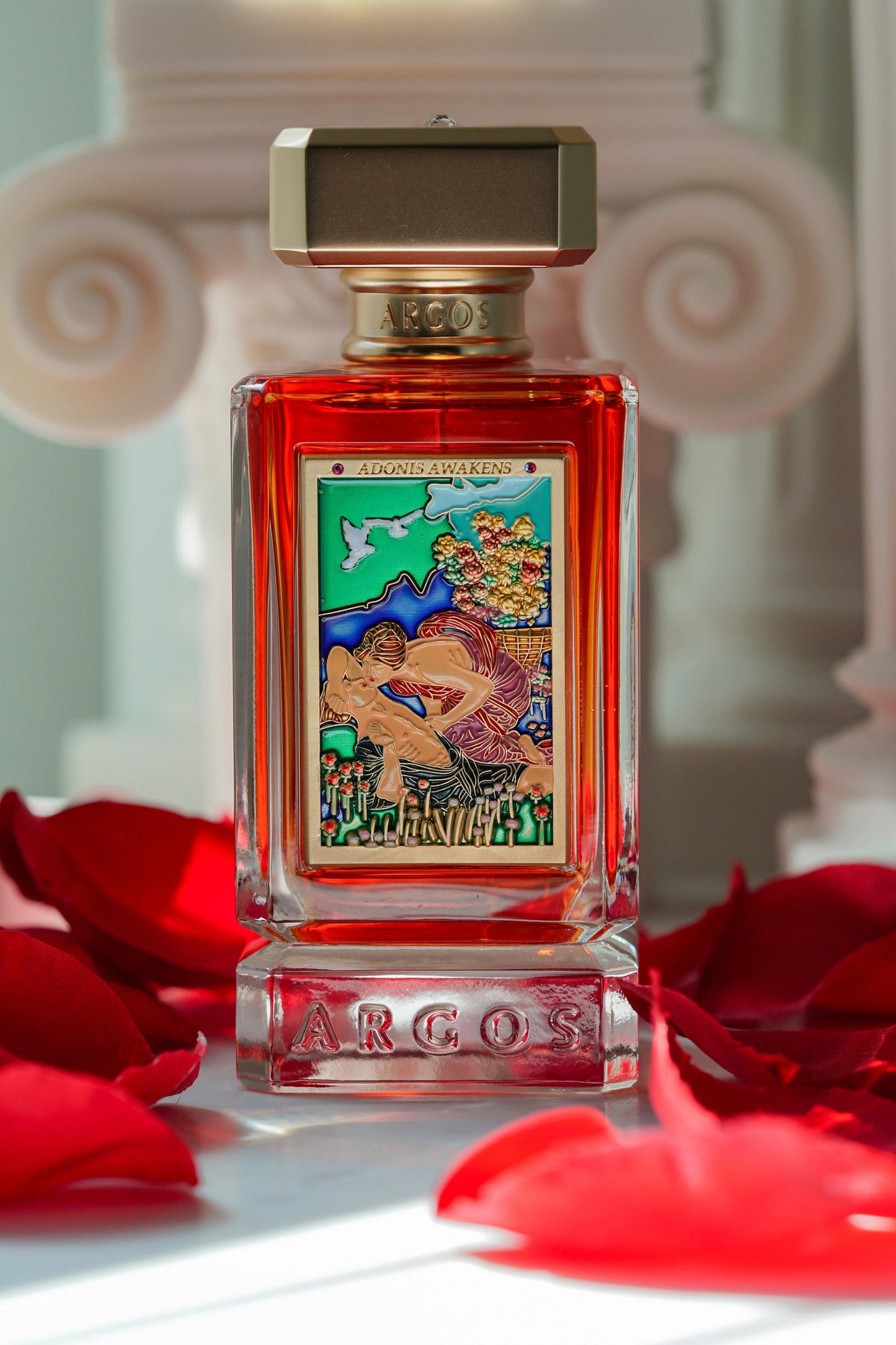 Perfume bottle with decorative label on a surface with red petals