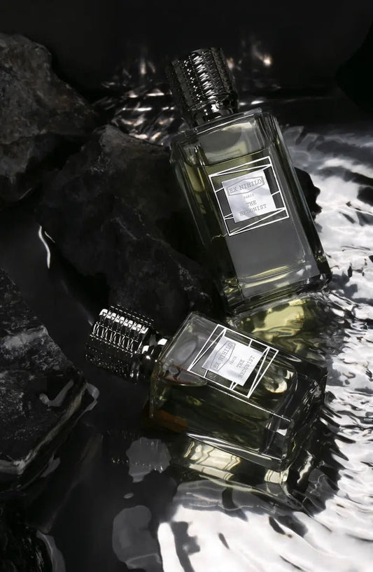 Two perfume bottles with visible labels on a textured surface