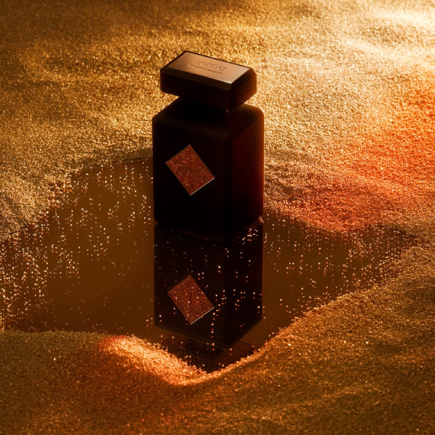 Dark bottle with a textured surface on a golden sandy background