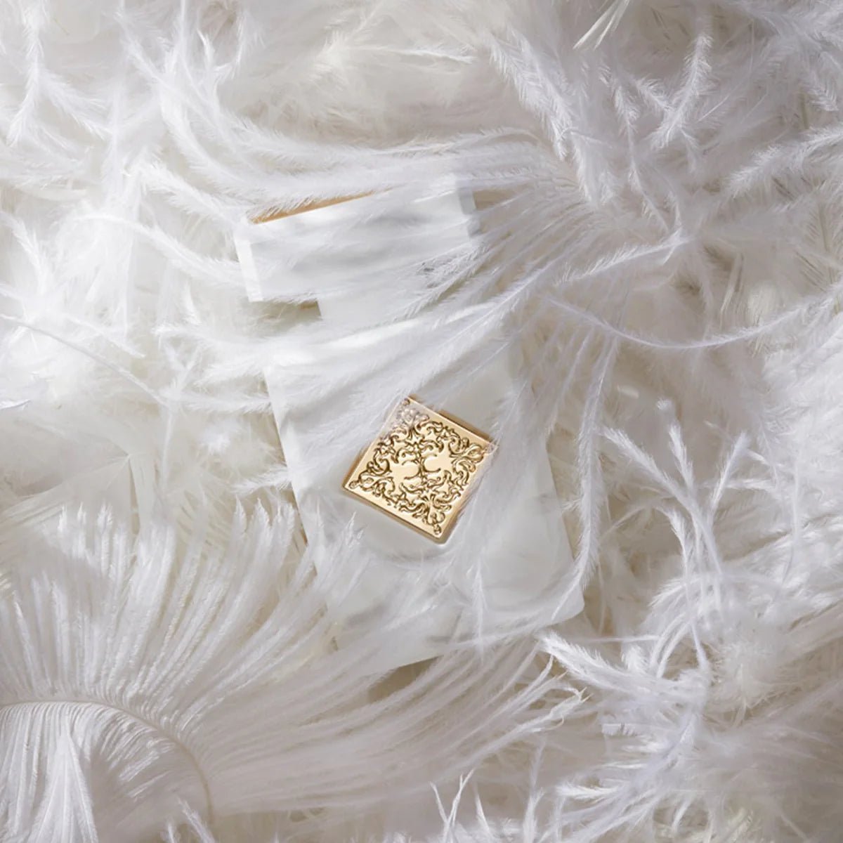 Gold decorative element on a white feathered surface