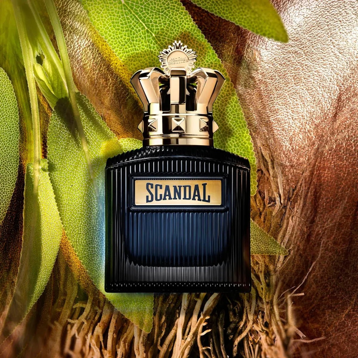Perfume bottle labeled 'Scandal' with a natural leafy background
