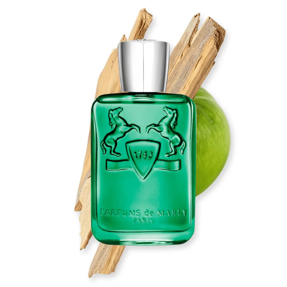 Green perfume bottle with silver cap and wooden elements on a white background