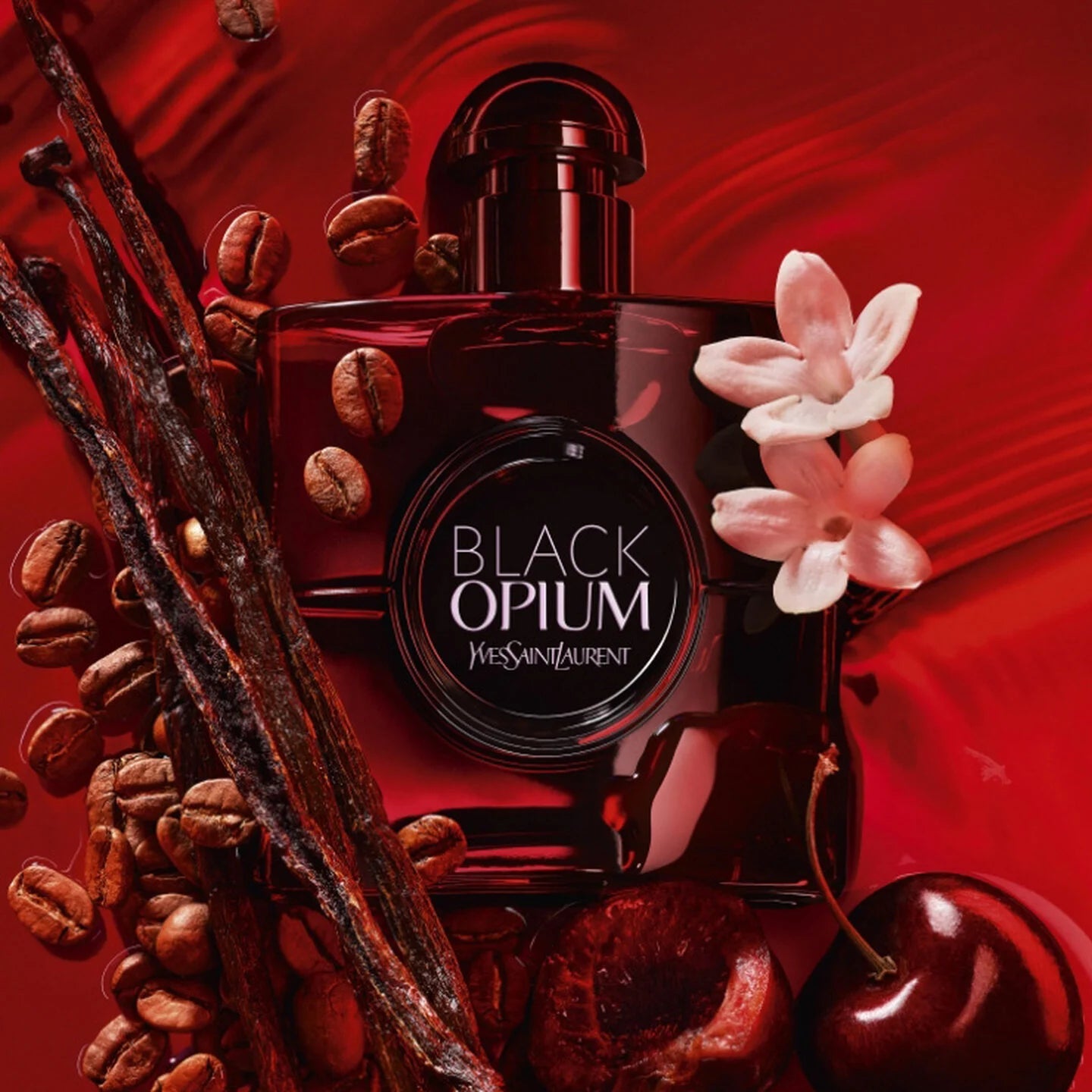 Yves Saint Laurent Black Opium perfume bottle with coffee beans, vanilla, and cherry on a red background