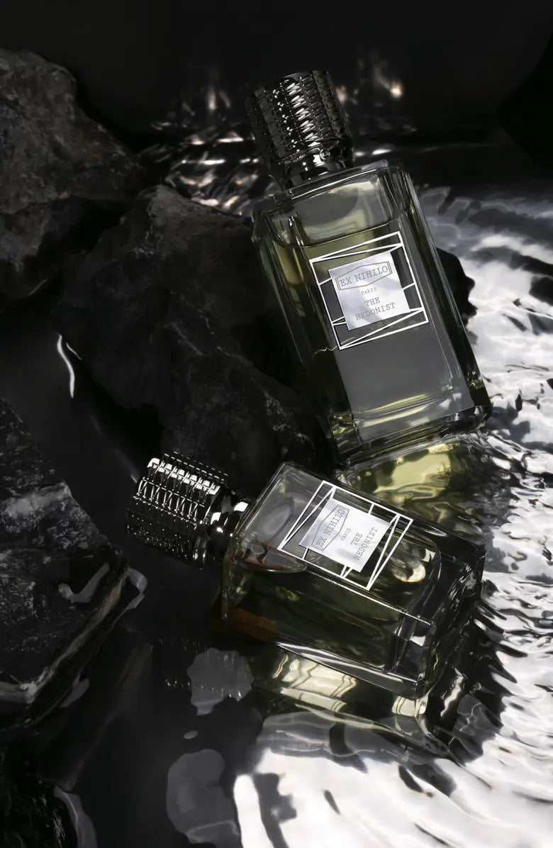 Two perfume bottles with visible labels on a textured surface