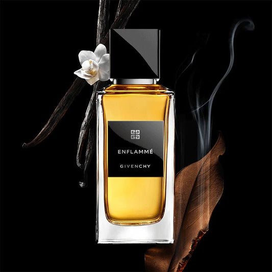 Givenchy Enflammé perfume bottle with vanilla bean and flower on a black background