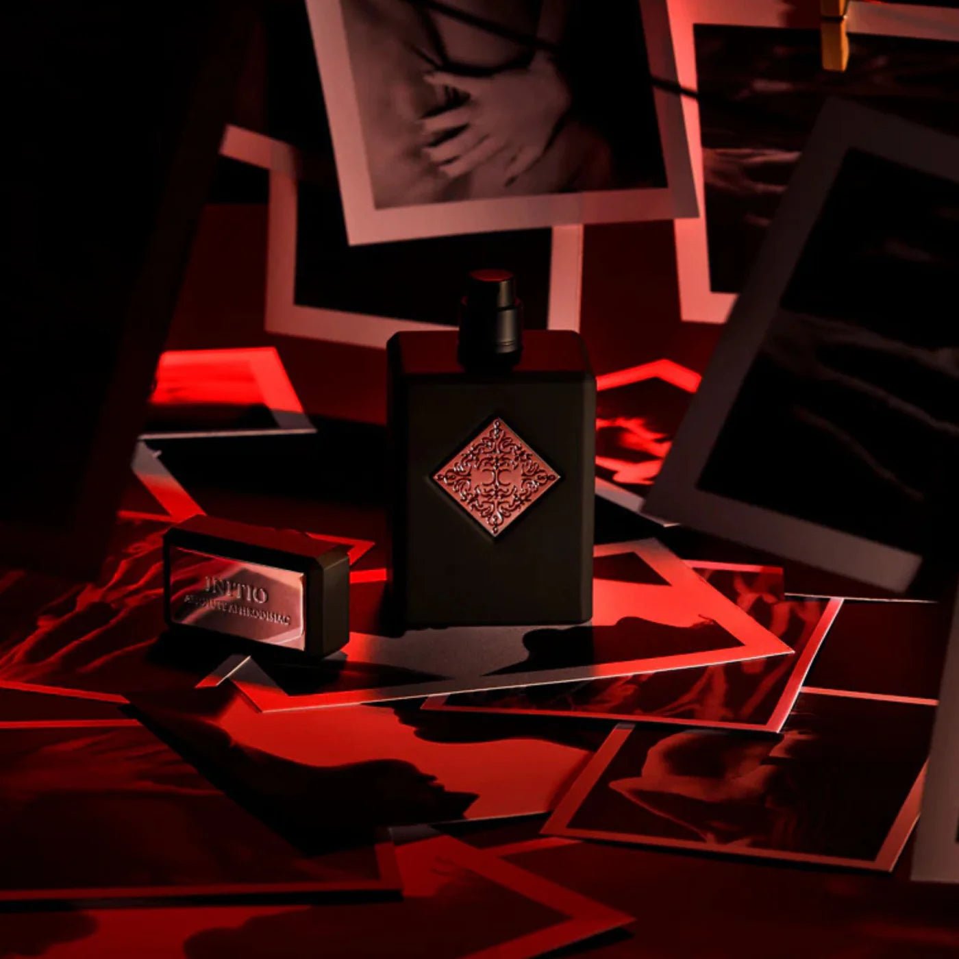 Black perfume bottle with decorative label on a reflective surface with red lighting