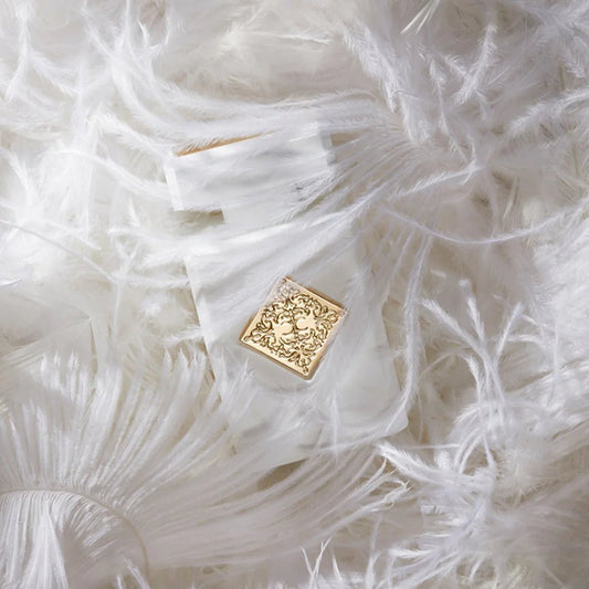 Gold decorative element on a white feathered surface