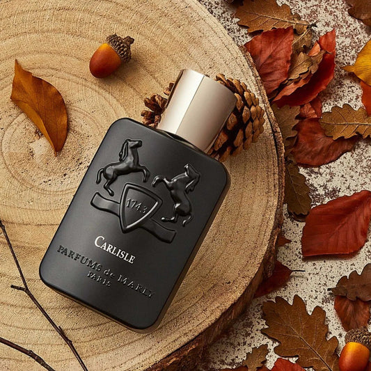 Black perfume bottle with silver cap on a wooden surface with autumn leaves